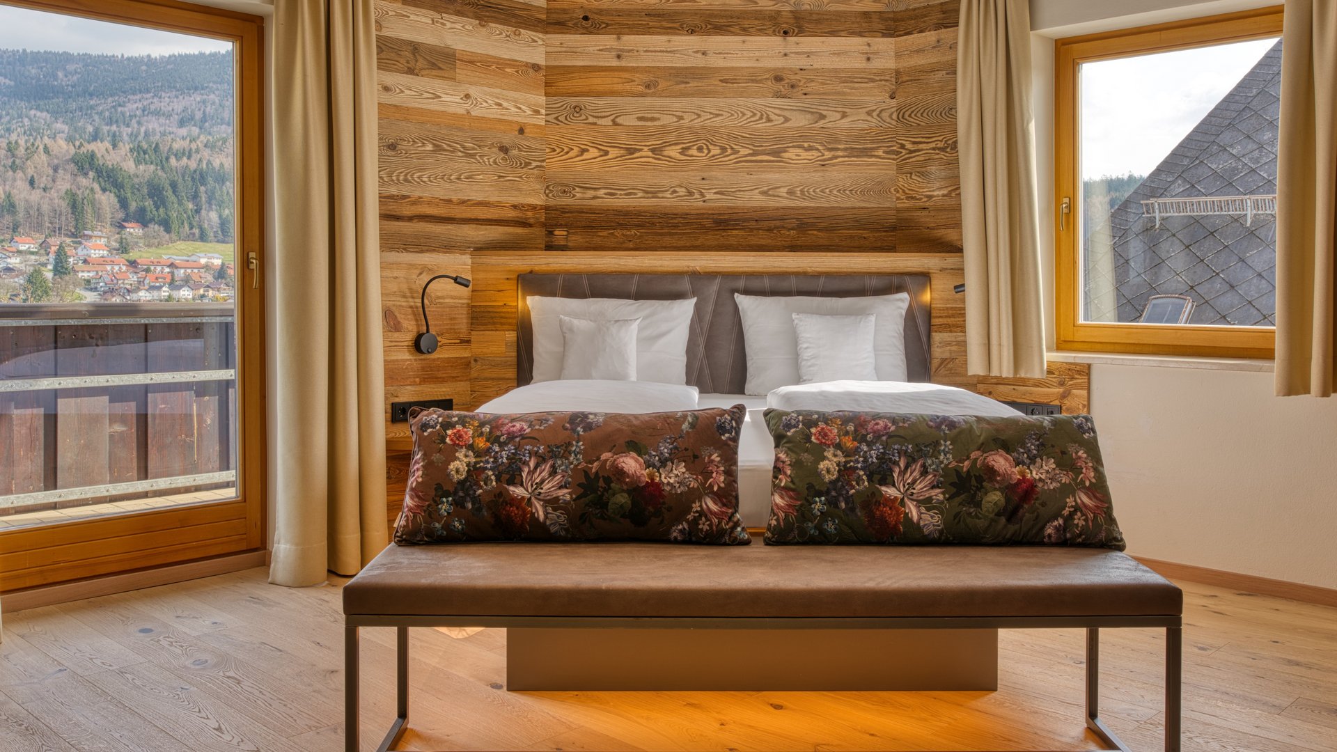 Ihr Traumurlaub im Hotel Hofbräuhaus Schlafzimmer der modernen Juniorsuite mit Panorama-Bergblick von Balkon und Fenster im 4-Sterne-Hotel Hofbräuhaus in Bodenmais, Niederbayern