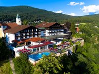Wellnesshotel im Bayerischen Wald - Das Hotel Hofbräuhaus Außenansicht des Wellnesshotels Hofbräuhaus in Bodenmais – Panoramablick auf Hotel, Außenpool, Saunen und Bayerischen Wald bei Sonnenschein