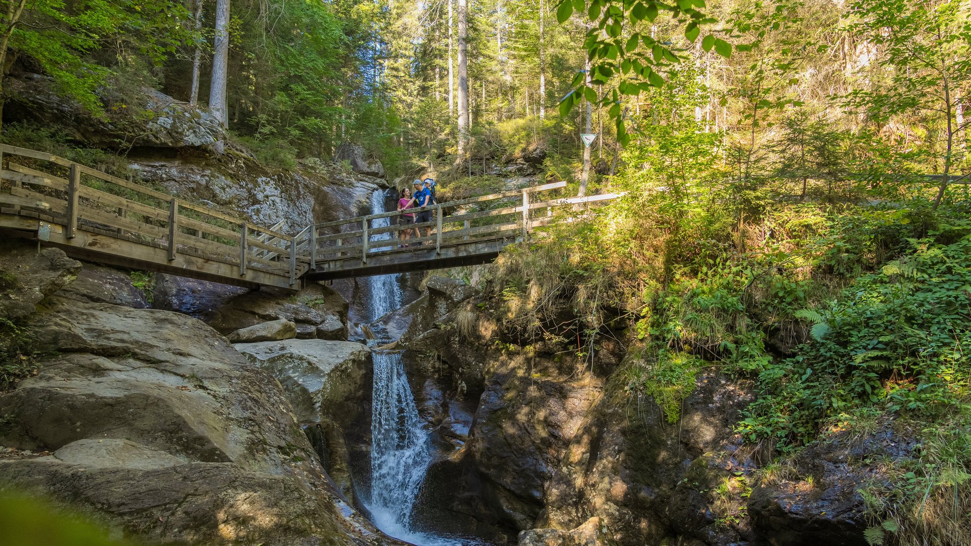 Wandern in Bodenmais: unsere Tipps Familie beim Wandern am Hochfall-Wasserfall auf Holzbrücke im Bayerischen Wald – Ausflugstipp nahe Wellnesshotel Hofbräuhaus Bodenmais