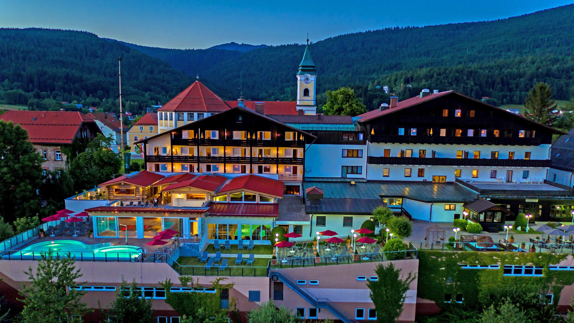 Hotel Hofbräuhaus - Ihr Wellnesshotel im Bayerischen Wald Wellnesshotel im Bayerischen Wald: Außenansicht des Wellnesshotel Hofbräuhaus in Bodenmais mit Außenpool, Saunen und Bergpanorama